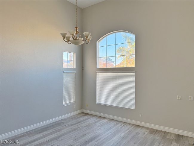 Spare room featuring baseboards, light wood finished floors, and a chandelier | Image 44