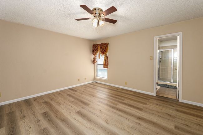 Empty room featuring ceiling fan, baseboards, a textured ceiling, and light wood finished floors | Image 6