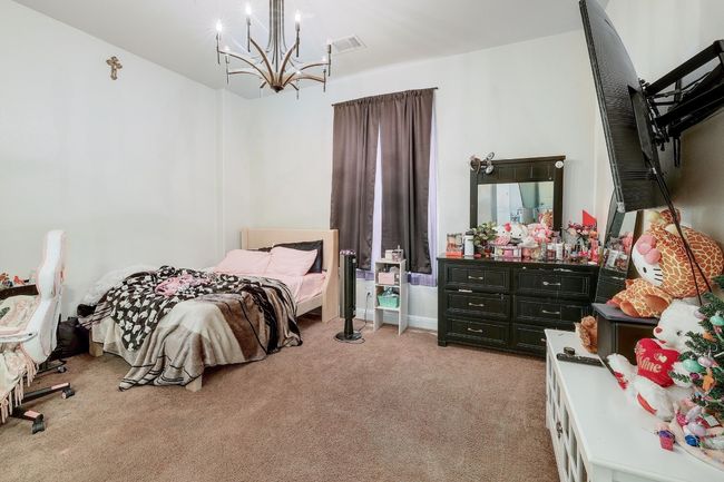 Bedroom featuring light carpet and a chandelier | Image 29