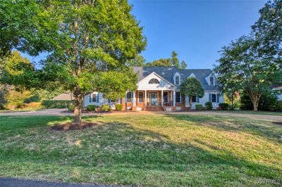 View of front of home with covered porch and a front yard | Image 1