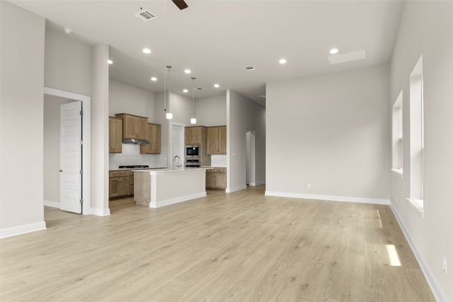 Unfurnished living room with a sink, recessed lighting, light wood-type flooring, ceiling fan, and baseboards | Image 10