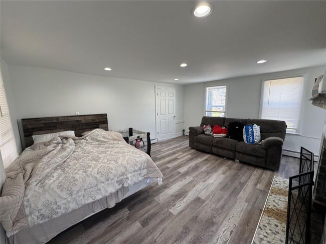 Bedroom with recessed lighting, wood finished floors, baseboards, and a baseboard heating unit | Image 4