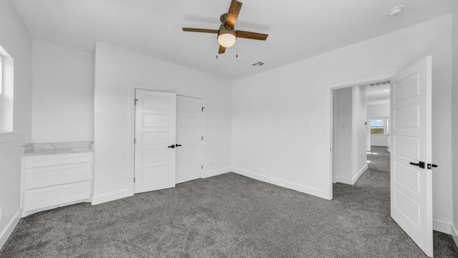 Unfurnished bedroom featuring visible vents, baseboards, a closet, and dark carpet | Image 32