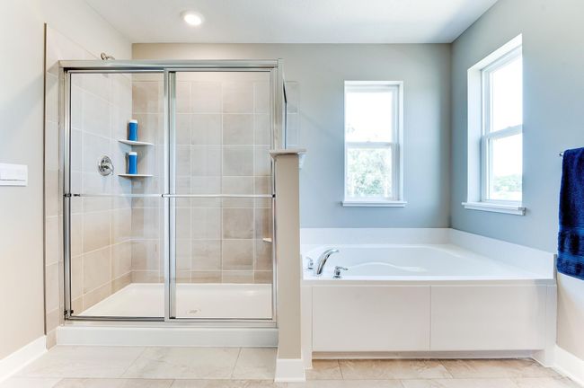 An extension of the primary suite, this private and spacious bathroom contains a double-vanity, an oversized stand-in shower, soaking tub, private stool room and access to a HUGE walk-in closet!! Photo of model home, color and options will vary. | Image 28