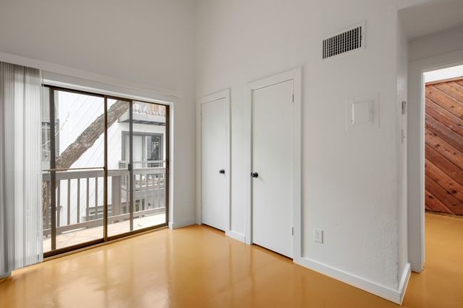 Unfurnished bedroom featuring visible vents, finished concrete floors, and access to outside | Image 12