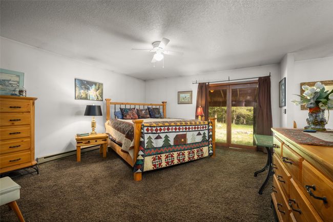 Bedroom with access to outside, carpet floors, a textured ceiling, heating, and ceiling fan | Image 13