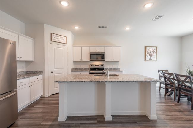 Kitchen with stainless steel appliances, a sink, dark wood-style floors, a kitchen island with sink, and recessed lighting | Image 8