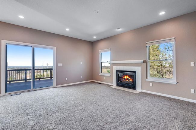 Unfurnished living room with recessed lighting, a tiled fireplace, carpet flooring, and baseboards | Image 10