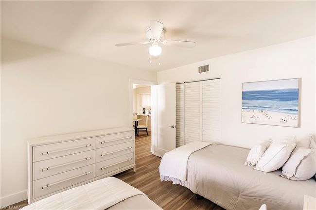Bedroom featuring dark wood-style floors, baseboards, visible vents, and a closet | Image 20