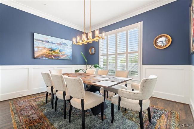 Dining space featuring a decorative wall, ornamental molding, a wainscoted wall, and a chandelier | Image 18