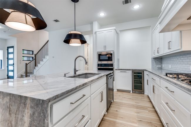Kitchen featuring light stone countertops, wine cooler, gas cooktop | Image 5