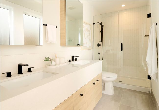 Bathroom featuring double vanity, a sink, a stall shower, and toilet | Image 6