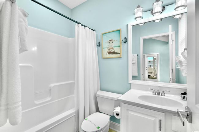 Bathroom with toilet, shower / bath combo with shower curtain, and vanity | Image 25