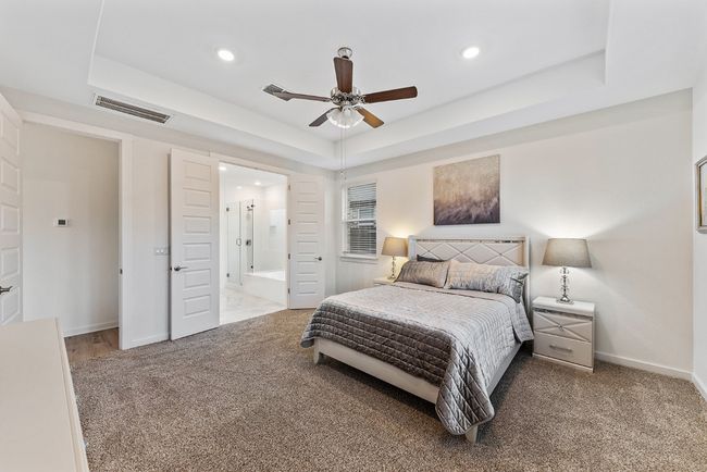 Bedroom featuring baseboards, visible vents, a raised ceiling, and carpet floors | Image 16