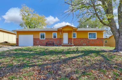 Ranch-style home featuring a garage and a front yard | Image 1