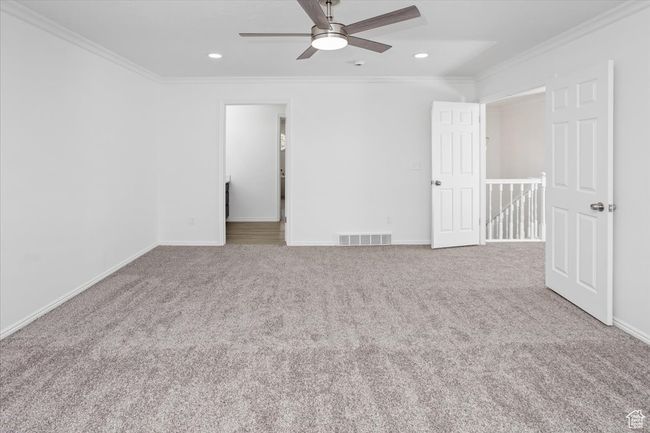 Unfurnished bedroom with baseboards, crown molding, carpet, and visible vents | Image 18