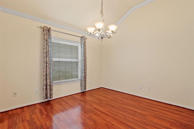 The dining room has tapered ceilings, crown molding and large picture window. | Image 4