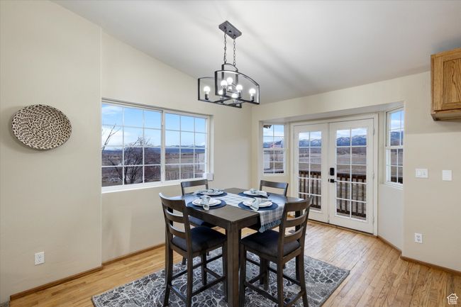 Dining space with light wood-type flooring, baseboards, a notable chandelier, and french doors | Image 8