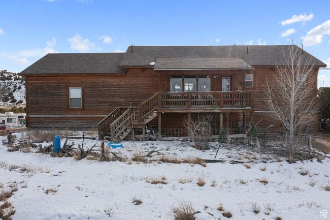 Snow covered back of property featuring a deck | Image 5