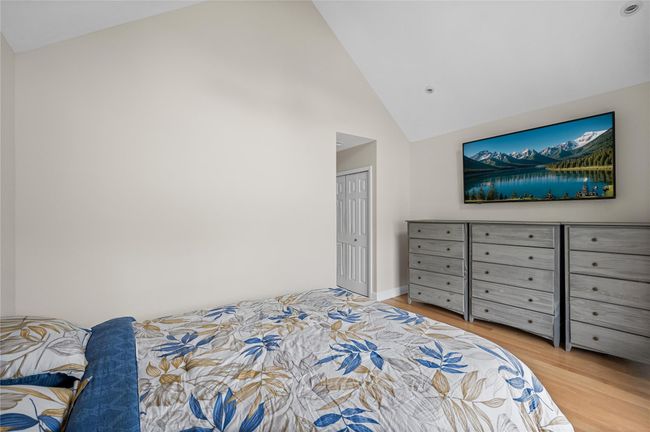 Bedroom with wood finished floors, high vaulted ceiling, and baseboards | Image 27