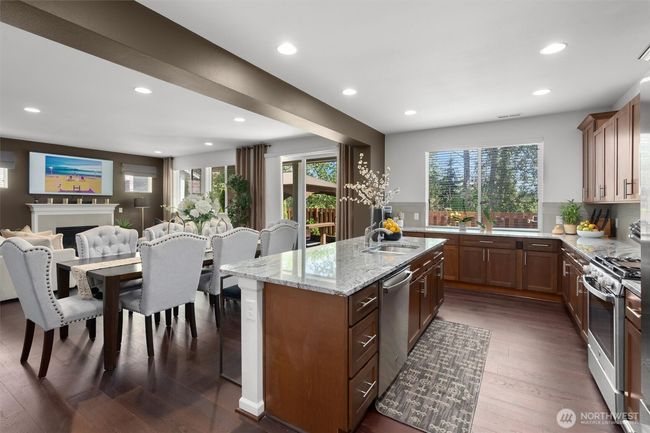 Enjoy the warm ambiance created by recessed lighting, rich hardwood floors and cabinetry, while oversized windows bring in natural light and offer views of the lush greenery outside. | Image 8
