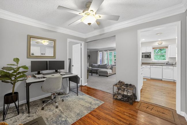 Office with light wood-type flooring, ceiling fan, plenty of natural light, crown molding, and a textured ceiling | Image 4