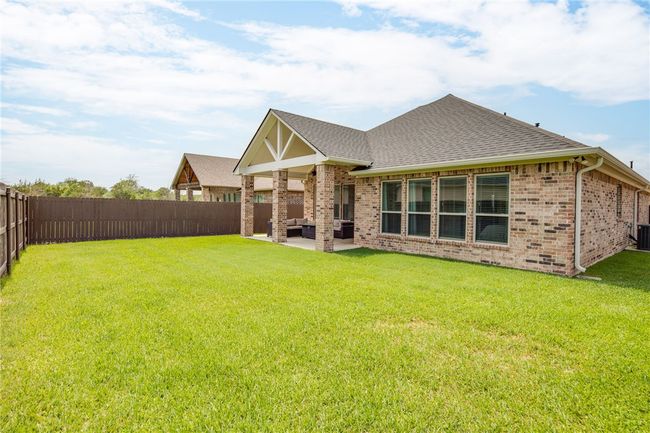 Back of property featuring roof with shingles, brick siding, an outdoor hangout area, a patio, and central air condition​​‌​​​​‌​​‌‌​‌‌​​​‌‌​​‌‌​‌​​​​​‌ unit | Image 22