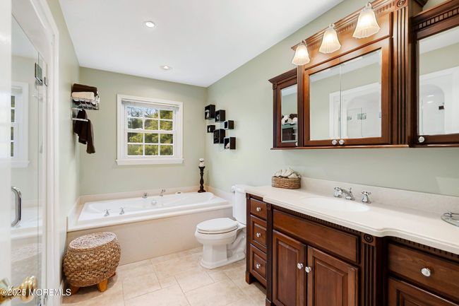 Air jetted soaking tub and plenty of cabinets in main bath | Image 30