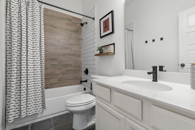 Bathroom with vanity, shower / tub combo with curtain, tile patterned floors, and toilet | Image 37