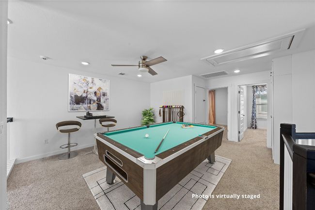 Playroom featuring a ceiling fan, attic access, billiards, light colored carpet, and visible vents | Image 24