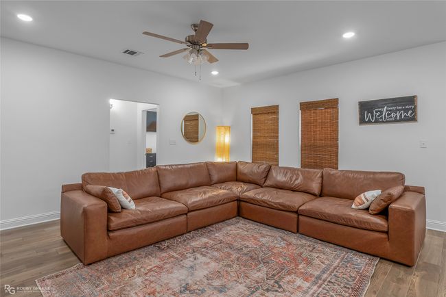 Living room with visible vents, light wood-style flooring, a ceiling fan, and recessed lighting | Image 4