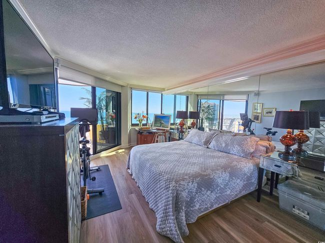 Bedroom featuring crown molding, a textured ceiling, and wood finished floors | Image 30