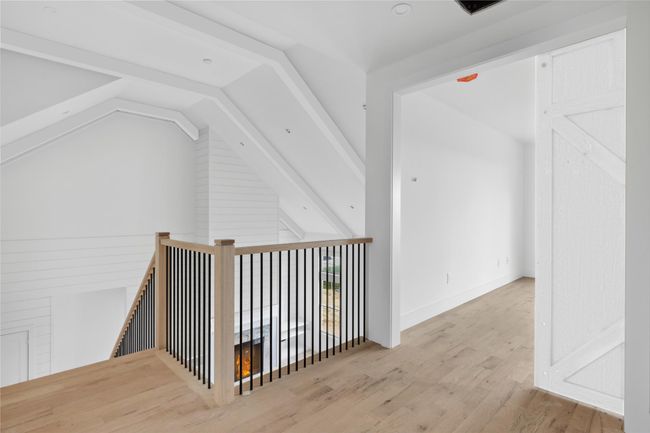 Hallway featuring an upstairs landing, vaulted ceiling, wood finished floors, and baseboards | Image 13