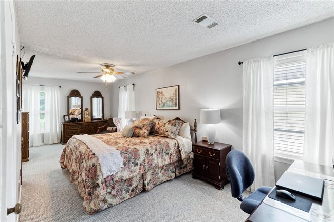 Oversized primary bedroom (25x11) provides ample space for a cozy sitting area & a home office setup, creating a versatile retreat to fit your lifestyle needs. | Image 11