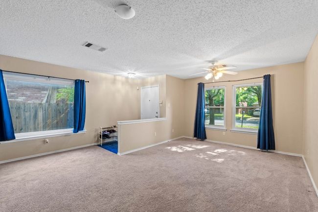 Unfurnished room with carpet floors, a ceiling fan, a textured ceiling, and baseboards | Image 6