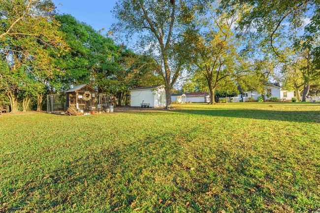 View of grassy yard featuring exterior structure and an outbuilding | Image 29