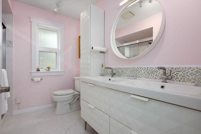 Bathroom with double vanity, marble look tile flooring, and a shower with door | Image 23