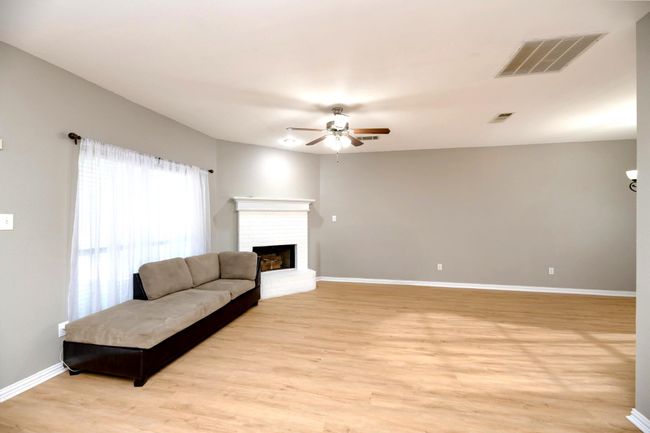 Living area featuring a ceiling fan, a fireplace, and light wood finished floors | Image 4
