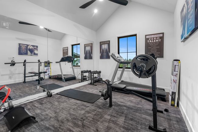 Workout room with ceiling fan, high vaulted ceiling, and baseboards | Image 29