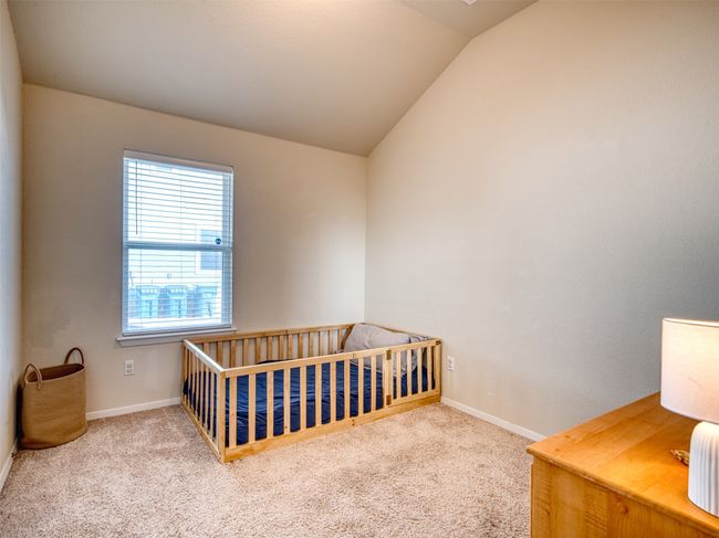Carpeted bedroom featuring a nursery area and lofted ceiling | Image 16
