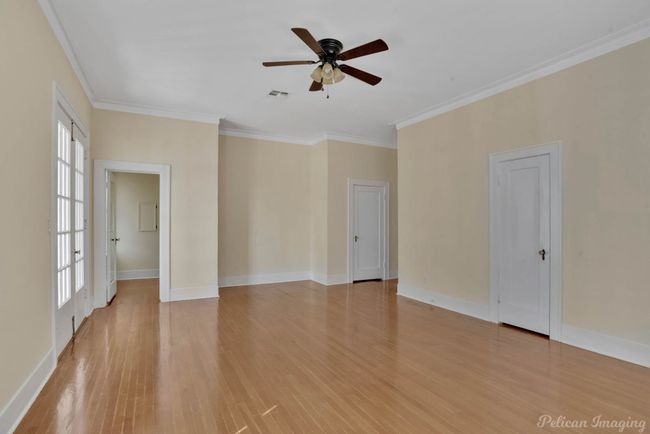 Spare room with healthy amount of natural light, light wood-style floors, crown molding, and a ceiling fan | Image 19