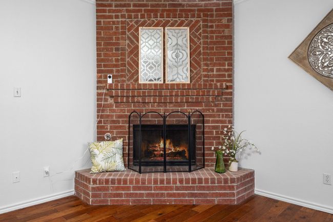 The brick fireplace in the family room has a gas starter and hearth. | Image 11