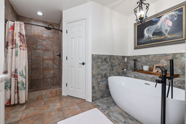 Full bathroom with stone finish floor, a tile shower, and a soaking tub | Image 15