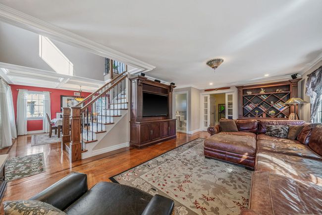 Living room featuring baseboards, ornamental molding, wood finished floors, recessed lighting, and stairway | Image 10