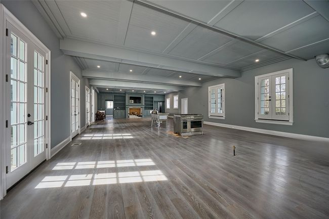Unfurnished living room featuring baseboards, wood finished floors, french doors, and a fireplace | Image 8
