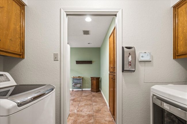 Washroom featuring cabinet space and washing machine and dryer | Image 18