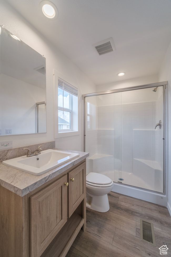 Full bathroom with vanity, a shower stall, toilet, and visible vents | Image 7