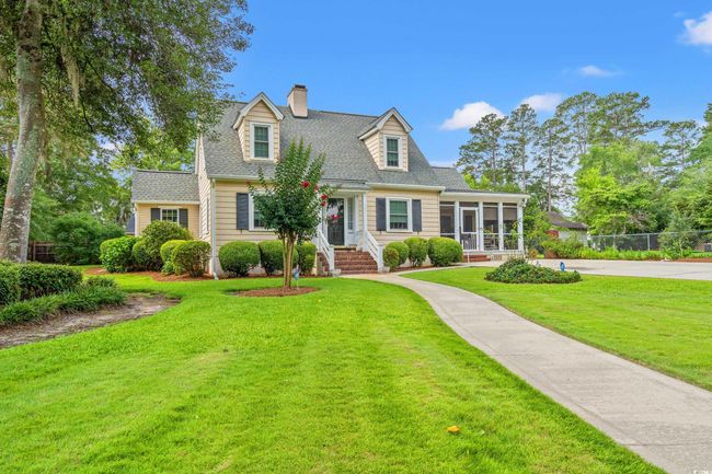 New england style home featuring a sunroom, a chimney, and a shingled roof | Image 26