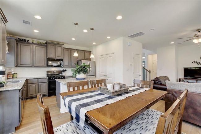 Dining area with light wood-type flooring, a ceiling fan, recessed lighting, and stairway | Image 14