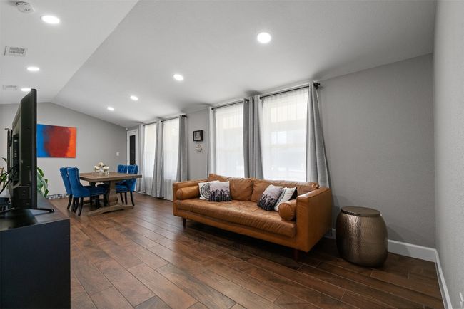 The main living area is a harmonious open concept, effortlessly connecting the kitchen, dining, and living spaces into a flowing, inclusive space | Image 5